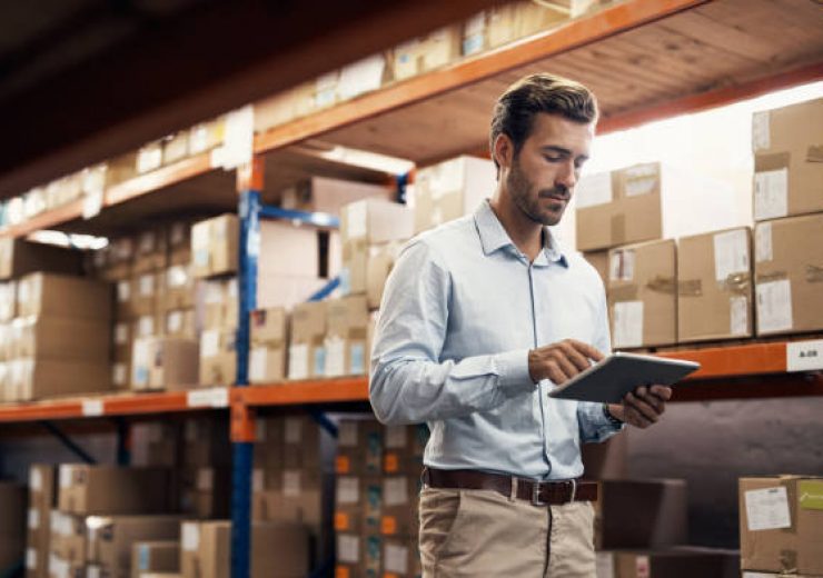 Shot of a young man using a digital tablet while working in a warehouse