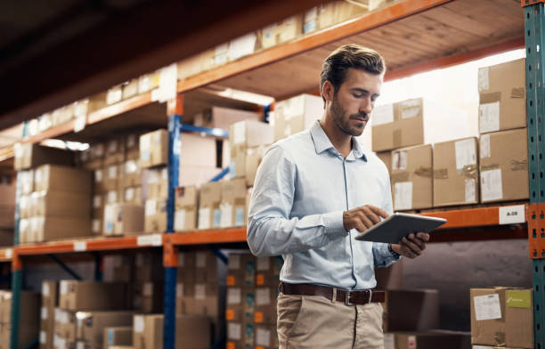 Shot of a young man using a digital tablet while working in a warehouse